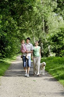 Eine Familie mit Hund macht einen Spaziergang durch den Wald